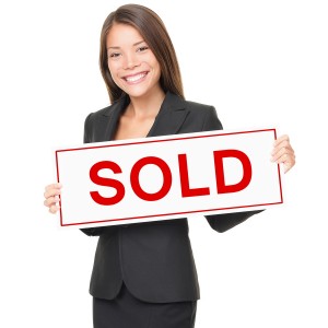 Real estate agent holding sold sign isolated on white background