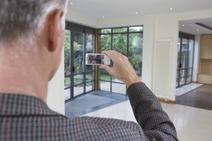Closeup rear view of a male real estate agent photographing new property